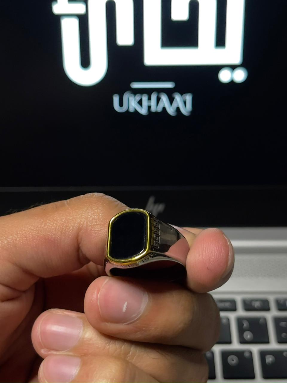 hand holding a Italian cutting ring with golden edges in front of laptop with "UKHAAI"branding |FRONT SIDE 