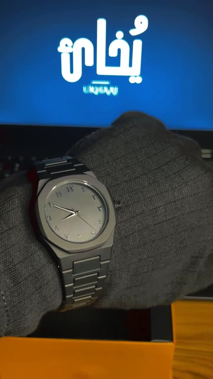 Black watch on a gloved hand with a brandind "Ukhaai"on it.(frontside)