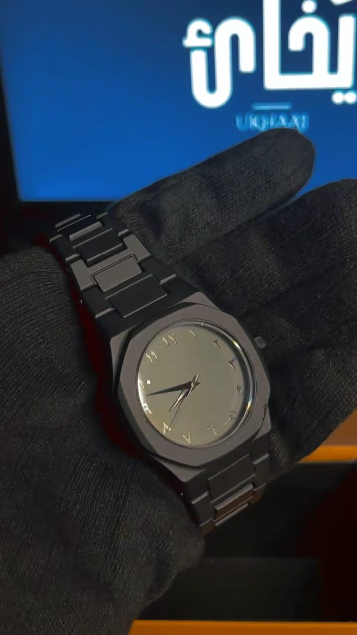 Black wristwatch on a gloved hand with a blurred background black strap  